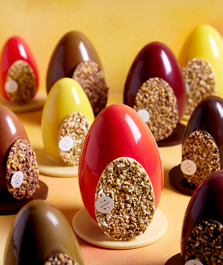 Oeuf de Pâques au chocolat blanc, paré de fruits secs et rempli d'oeufs pralinés - Grand format
